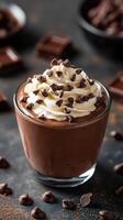 Decadent chocolate mousse topped with whipped cream and chocolate chips on a dark background photo