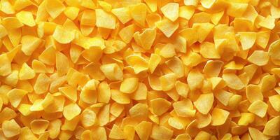 Yellow dried mango pieces spread out on a flat surface in bright natural light photo