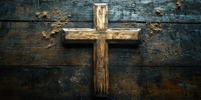Wooden cross displayed on a rustic wooden surface with sandy texture and a serene ambiance in a dimly lit room photo