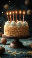 Celebratory cake with lit candles surrounded by nuts and festive decorations at an evening gathering photo