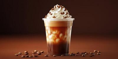 Creamy coffee drink topped with whipped cream and coffee beans in a clear cup on a brown background photo