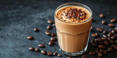 Creamy coffee drink topped with chocolate sprinkles and coffee beans on a black table photo