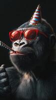 Gorilla celebrating in party hat and sunglasses with a festive straw photo