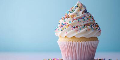 Delicious cupcake with colorful sprinkles on a light blue background photo