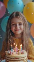 Young child celebrates birthday with colorful cake and balloons photo
