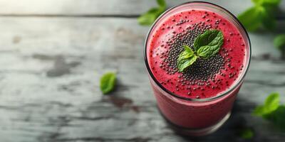 Refreshing berry smoothie with mint leaves and chia seeds on a rustic wooden table photo