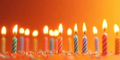 Colorful birthday candles flickering on a festive orange background during a celebration photo