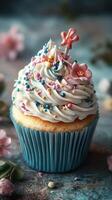Colorful cupcake adorned with festive sprinkles and delicate flowers in a charming setting photo