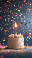 Colorful birthday cake with a lit candle surrounded by confetti celebrating a joyful occasion photo