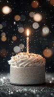 Celebration cake with a lit candle surrounded by sparkling decorations during a festive event photo