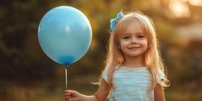 Happy child holding a blue balloon outdoors during golden hour in a park setting photo
