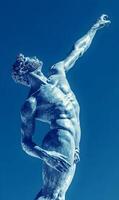 Bronze Statue Reaching Upward Against a Vibrant Sky, Depicting Human Form and Expression photo