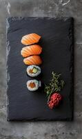 Artistic arrangement of salmon nigiri, rolls with sprouts and ginger on stone surface photo
