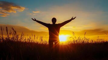 Person with arms wide open in field at sunrise, a moment of absolute freedom photo