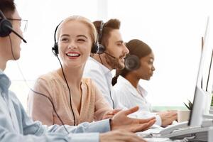 Call centre and customer service concept. Tech support operators discussing something at workplace photo