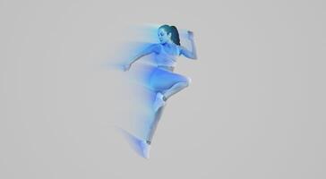 A woman wearing a blue outfit is captured mid-air as she jumps. Her joyful expression is evident as she defies gravity. The background is grey, emphasizing her movement, copy space photo