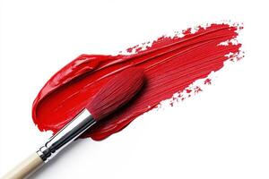 Bright red paint applied with a brush on a clean canvas photo