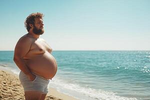 Man with a belly standing on a beach under bright sun photo