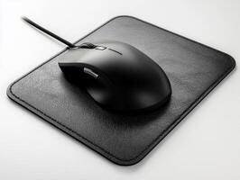 Black computer mouse on leather mouse pad in a workspace photo