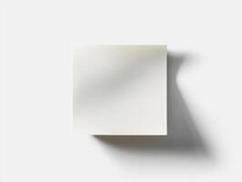 Blank square notepad on a light background casting a soft shadow photo