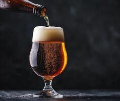 Pouring craft beer into a glass with frothy head photo