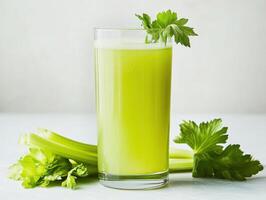 Fresh celery juice served in a clear glass with greenery photo