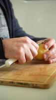 Man is Peeling Boiled Potato with Knife on a Cutting Board. Vertical . Close-Up Shot video