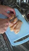 Man is Cutting and Slicing Chicken Breast with Knife on a Cutting Board. Vertical . Close-Up Shot video