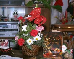 A basket with flowers and a christmas card on a table photo
