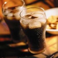 Two glasses of cola sit on a table photo