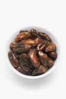 A bowl of dates on a white background photo