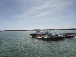 A boat is docked at a dock with a bridge photo
