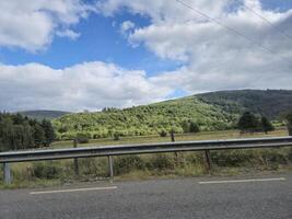 A view of a road with a hill in the background photo