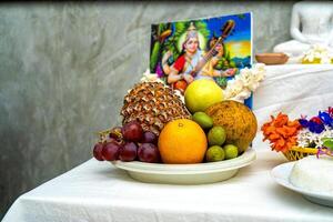A table with fruit and a picture of a buddha photo
