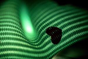 A black and green striped fabric with a black spot on it photo