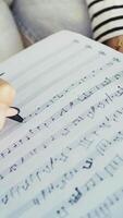 Girl Writes Notes On A Sheet Music To Play Them With The Ukulele video