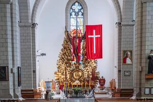 Altar with Jesus Christ and a cross in interior of a white Christian Catholic church. Cathedral of Sacred Heart of Jesus. Tashkent, Uzbekistan - April 18, 2024 photo
