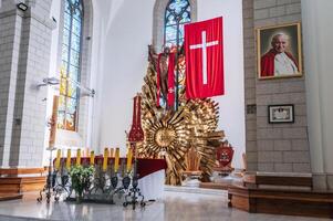 Altar with Jesus Christ and a cross in the interior of a white Christian Catholic church. Cathedral of Sacred Heart of Jesus. Tashkent, Uzbekistan - April 18, 2024 photo