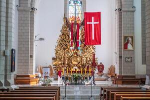 Altar with Jesus Christ and a cross in interior of a white Christian Catholic church. Cathedral of Sacred Heart of Jesus. Tashkent, Uzbekistan - April 18, 2024 photo