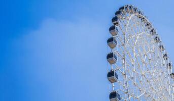 white big Ferris wheel on background clear blue sky in fair in summer with copy space photo