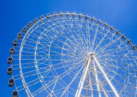 white big ferris wheel on background a clear blue sky in Navruz Park in Tashkent in summer photo