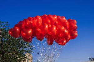 many red balloons in shape of a heart on the background of blue sky photo