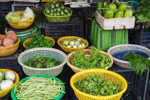 assortment of various vegetables and herbs at street grocery and vegetable market in Asia in Vietnam photo