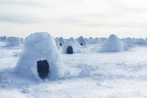 Igloo holiday. Eskimo dwelling made of ice and snow. Lots of igloo built photo