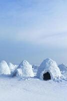Igloo holiday. Eskimo dwelling made of ice and snow. Lots of igloo built, Vertical photo