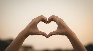 Hands making heart shape with blurred background photo