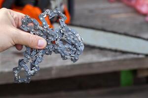 New chain for chainsaw. Setting up and replacing the chain on the chainsaw from the old to the new. Chain sharpening. photo
