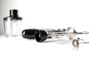Modern set for immersion blender with whisk, milk frother and bowl on white background. Modern household appliances, close-up. Copy space for text photo