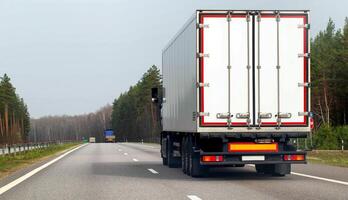 A new truck with a white isothermal semi-trailer transports a load of medicines to a pharmacy that require temperature control. A truck carries cargo in the spring against the backdrop photo