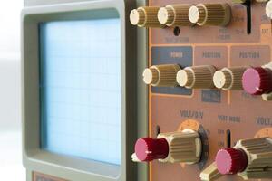 Old oscilloscope panel showing controls and blank screen in a vintage lab setting photo